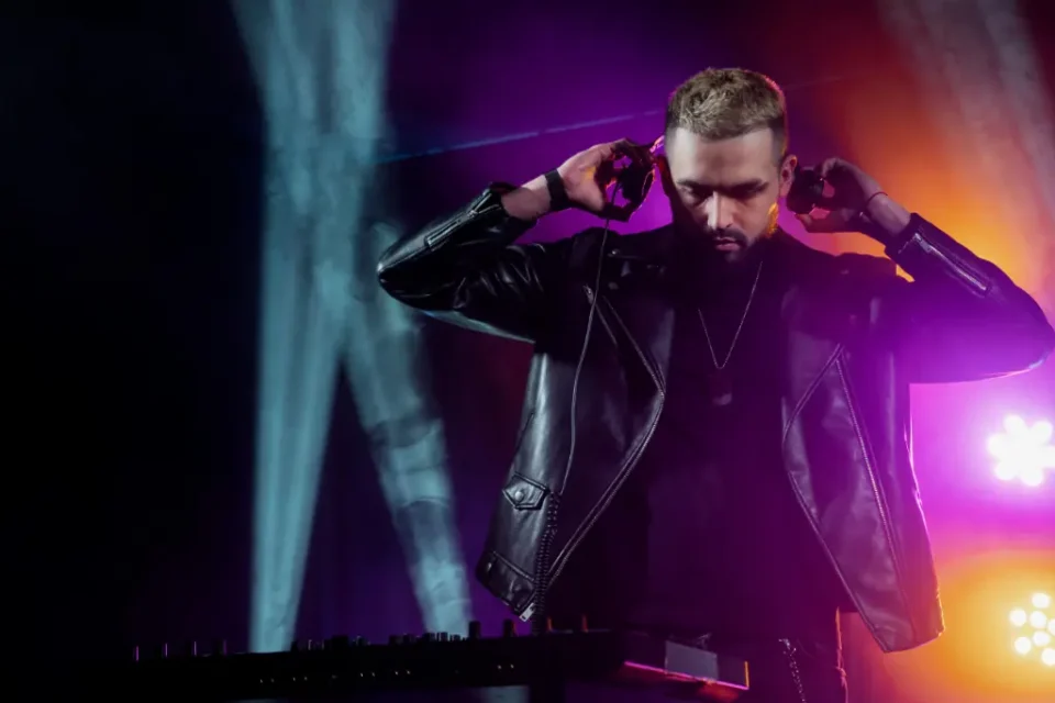 A man with headphones DJing on stage